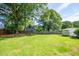 A large backyard featuring well-maintained grass, a privacy fence, shed, and mature shade trees at 4150 Glenn St, Powder Springs, GA 30127