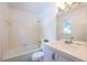 Bathroom featuring white tiling, a shower-tub combo, and a sleek vanity sink at 4150 Glenn St, Powder Springs, GA 30127