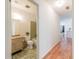 Bathroom with a vanity, toilet, and shower/tub combo; hall with hardwood flooring at 4150 Glenn St, Powder Springs, GA 30127