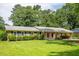 Well-kept single-story home featuring a green lawn, tidy shrubs, and a convenient covered parking area at 4150 Glenn St, Powder Springs, GA 30127