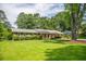 Pleasant single-story home with manicured lawn, mature trees, and a covered parking area for convenience at 4150 Glenn St, Powder Springs, GA 30127