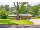 Inviting single-story home with lush green lawn and a large tree, creating a picturesque and serene setting at 4150 Glenn St, Powder Springs, GA 30127