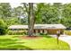 Charming single-story home featuring a well-manicured lawn and mature trees, complemented by a welcoming facade at 4150 Glenn St, Powder Springs, GA 30127