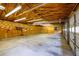 View of a spacious three car garage with an exposed beam ceiling, lots of lighting, and a wood paneled accent wall at 4150 Glenn St, Powder Springs, GA 30127