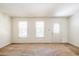 Bright living room featuring neutral carpet, two windows, and a front door with decorative glass at 4150 Glenn St, Powder Springs, GA 30127