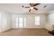 Bright living room featuring neutral carpet, a ceiling fan, and access to the backyard through French doors at 4150 Glenn St, Powder Springs, GA 30127