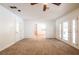 Bright living room featuring neutral carpet, a ceiling fan, and access to another room at 4150 Glenn St, Powder Springs, GA 30127