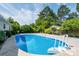 A sparkling in-ground pool with a ladder is surrounded by lush greenery, creating a private backyard oasis at 4150 Glenn St, Powder Springs, GA 30127