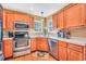 Kitchen featuring stainless steel appliances, wooden cabinets, hardwood floor, and a window over the sink at 8870 Dornoch Cir, Winston, GA 30187
