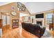 Living room featuring hardwood flooring, a brick fireplace, a large sectional sofa, and kitchen view at 8870 Dornoch Cir, Winston, GA 30187