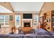 Living room featuring a brick fireplace, hardwood flooring, vaulted ceilings, and a large sectional sofa at 8870 Dornoch Cir, Winston, GA 30187
