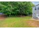 Large backyard with lush trees and a patio with outdoor seating at 1087 Berkley Se Dr, Smyrna, GA 30082