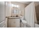 Well-lit bathroom featuring a granite vanity, a toilet, and a shower with a white shower curtain at 1087 Berkley Se Dr, Smyrna, GA 30082
