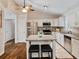 Eat-in kitchen with white cabinets, granite counters, stainless appliances, island with seating and hardwood floors at 1087 Berkley Se Dr, Smyrna, GA 30082