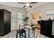 Well-lit home office space with neutral walls, a ceiling fan, contemporary furniture and a view into the dining area at 1087 Berkley Se Dr, Smyrna, GA 30082