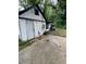 Side of a white house with black trim, a door, a cement slab, and garbage cans at 2463 Stone Rd, East Point, GA 30344