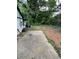 View of a large cement slab leading to an overgrown green backyard at 2463 Stone Rd, East Point, GA 30344