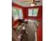 Red bedroom featuring two bright windows and assorted trash on the carpeted floor at 2463 Stone Rd, East Point, GA 30344