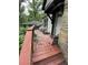 View of the wooden front porch featuring red wood, steps, and wooded scenery at 2463 Stone Rd, East Point, GA 30344