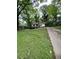 View of a white house with a chimney surrounded by many lush green trees at 2463 Stone Rd, East Point, GA 30344