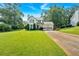 Landscaped front yard featuring a two-story home with a two-car garage and a basketball hoop, set against a backdrop of mature trees at 285 Sw Martin Sw Way, Marietta, GA 30064
