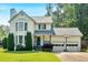 Charming two-story home with a well-manicured lawn, mature trees, and an attached two-car garage with a basketball hoop at 285 Sw Martin Sw Way, Marietta, GA 30064