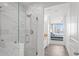 Bright bathroom features a glass enclosed shower with white marble-style tile and modern fixtures at 3338 Peachtree Rd # 2005, Atlanta, GA 30326