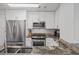 The kitchen has stainless steel appliances, including a double-door refrigerator, with granite countertops and white cabinetry at 3338 Peachtree Rd # 2005, Atlanta, GA 30326