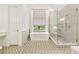 Bright bathroom features a freestanding tub, glass enclosed shower with multiple shower heads at 3925 Sheldon Ne Dr, Atlanta, GA 30342