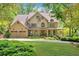Stunning two-story home boasts a three-car garage, a manicured lawn, and a charming front porch, all surrounded by lush greenery at 3925 Sheldon Ne Dr, Atlanta, GA 30342