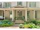Charming home featuring a covered front porch, lush landscaping, and stylish exterior lighting at 3925 Sheldon Ne Dr, Atlanta, GA 30342