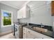 Laundry room featuring modern appliances, black granite countertop, and white cabinets with a bright window view at 3925 Sheldon Ne Dr, Atlanta, GA 30342