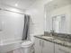 Clean bathroom featuring tiled walls, shower, and granite countertop at 943 Peachtree Ne St # 716, Atlanta, GA 30309