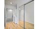 Bright bedroom featuring a mirrored closet, wooden floors, and access to a full bathroom at 943 Peachtree Ne St # 716, Atlanta, GA 30309