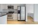 Modern kitchen with stainless steel appliances, white cabinets, and granite countertops with open bedroom view at 943 Peachtree Ne St # 716, Atlanta, GA 30309