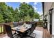 Outdoor deck with a large wooden table, seating for six, and a beautiful view of the lush backyard at 221 Brooke Dr., Alpharetta, GA 30009