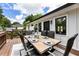 Outdoor deck has a large wooden table, seating for six, and is partially shaded by surrounding trees at 221 Brooke Dr., Alpharetta, GA 30009