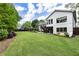 Spacious backyard with lush lawn, mature trees, and a charming two-story home at 221 Brooke Dr., Alpharetta, GA 30009