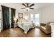 Cozy bedroom with hardwood floors, soft decor, and a comfortable sitting area next to the window at 221 Brooke Dr., Alpharetta, GA 30009