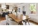Bright dining room boasts a wooden table, seating for eight, natural light, and access to the outdoor patio at 221 Brooke Dr., Alpharetta, GA 30009