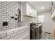 Clean laundry room with tile floors, washer/dryer, dog washing station and plenty of cabinet space at 221 Brooke Dr., Alpharetta, GA 30009