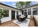 This outdoor patio features a dining table, modern chairs, and a rustic wood deck overlooking a scenic backyard at 221 Brooke Dr., Alpharetta, GA 30009
