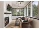 A cozy sunroom features a fireplace and large windows offering a beautiful view at 221 Brooke Dr., Alpharetta, GA 30009
