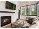 Bright sunroom featuring a fireplace, comfortable seating, and expansive windows showcasing the outdoor scenery at 221 Brooke Dr., Alpharetta, GA 30009