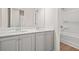 Bright bathroom featuring a double vanity with grey cabinets and a bathtub shower with white tile surround at 603 River Gardens Se Dr, Atlanta, GA 30354
