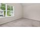 Bright bedroom with neutral carpet, large window, and serene view of outdoor greenery at 603 River Gardens Se Dr, Atlanta, GA 30354