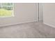 Bedroom with neutral carpet, a large window, and a white door for a bright, cozy atmosphere at 603 River Gardens Se Dr, Atlanta, GA 30354
