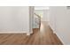Bright hallway featuring wood-look floors, neutral paint, white trim, and an oak staircase with black iron balusters at 603 River Gardens Se Dr, Atlanta, GA 30354