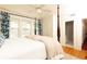 Bright bedroom with a white comforter, four poster bed, hardwood floors, and blue patterned curtains at 824 Greenwood Ne Ave # 9, Atlanta, GA 30306