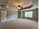 Spacious primary bedroom with a tray ceiling, ceiling fan, and large window at 3522 Fallen Oak Dr, Buford, GA 30519